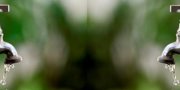 Foto de uma torneira soltando agua, a foto está sendo espelhada.