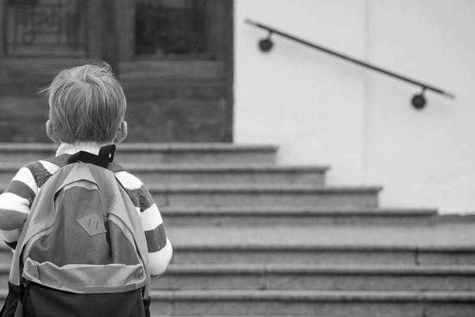 Foto em preto e branco de criança com mochila