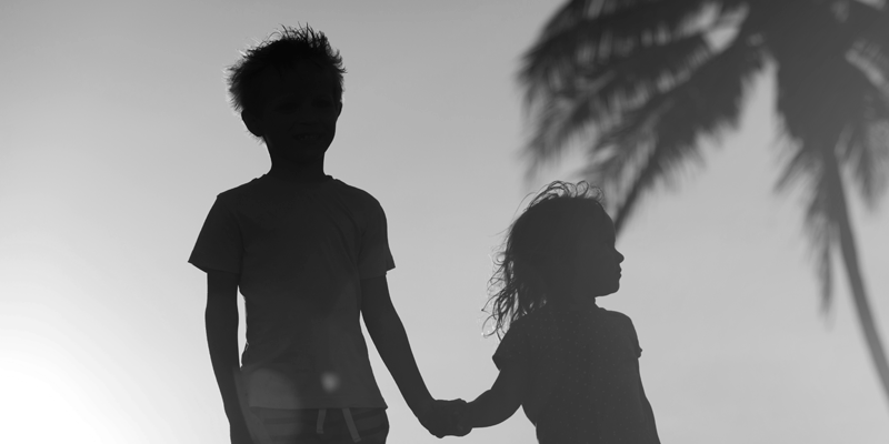 hghhg Foto em preto e branco, contraluz, de duas crianças de mãos dadas