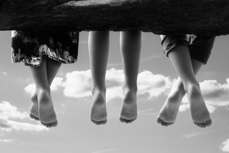 Foto em preto e branco dos pés de três crianças