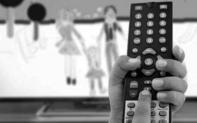 Foto em preto e branco de controle remoto em frente à TV