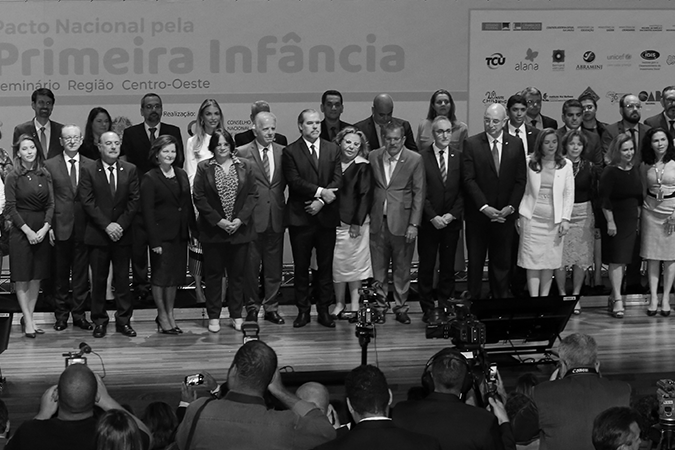 Foto em preto e branco do evento de lançamento do Pacto Nacional pela Primeira Infância, com várias pessoas sobre palco