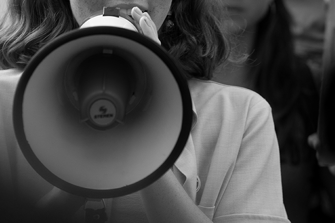 Foto em preto e branco de criança segurando um megafone