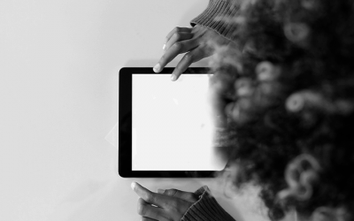 Foto em preto e branco de adolescente mexendo em tablet representa a questão da privacidade de dados