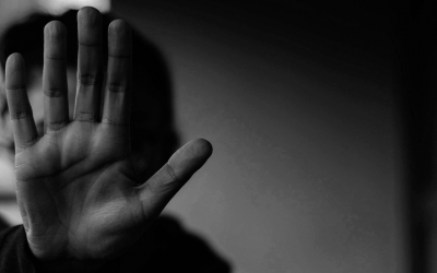 Foto em preto e branco mostra adolescente com a mão estendida em sinal de "pare", em referência a letalidade policial