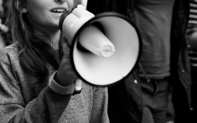 Foto em preto e branco mostra criança com megafone em manifestação. Representa o ato em defesa do Conanda