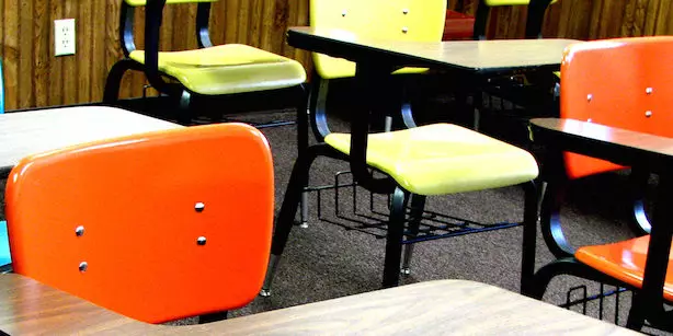 Imagem de carteiras de uma escola.