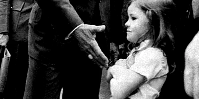 Ditadura Foto em preto e branco de João Figueiredo, à época (1979) presidente do Brasil, com a mão estendida para cumprimentar criança que se recusa, com os braços cruzados.