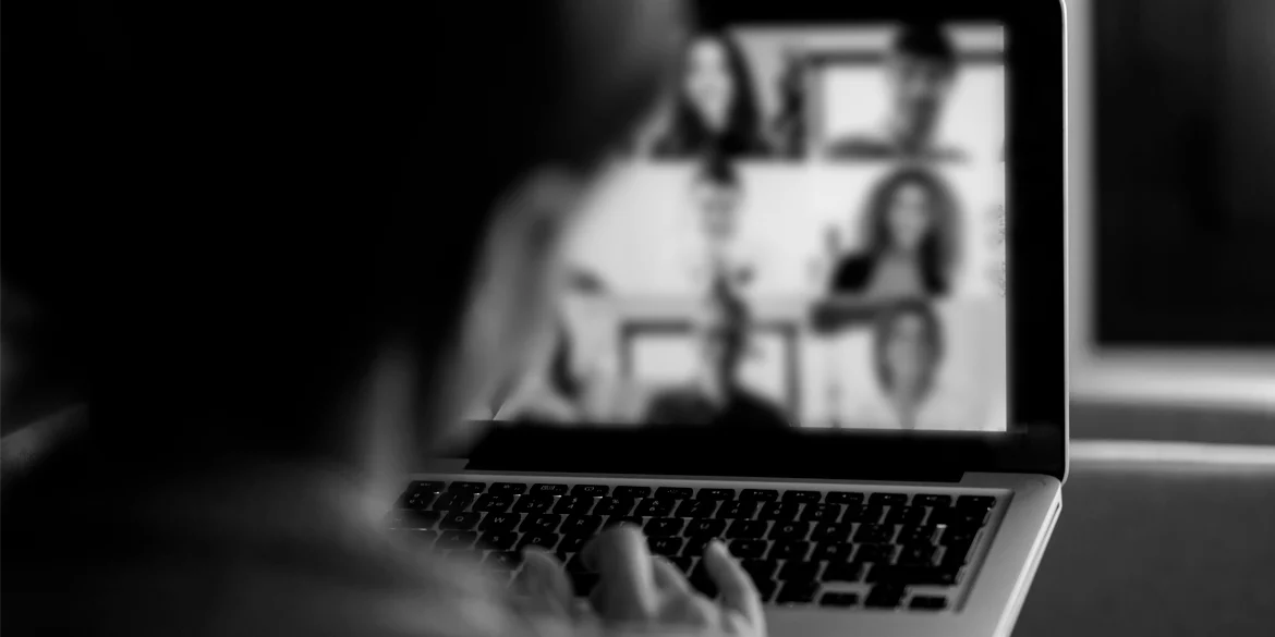 Foto em preto e branco mostra jovem em frente ao computador representando adolescente em uma audiência por videoconferência